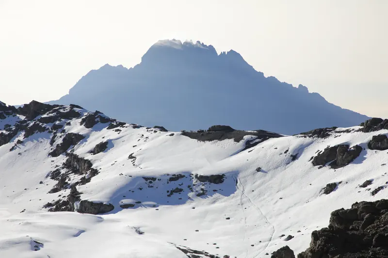 A rugged peak rising beyond a snow-covered landscape